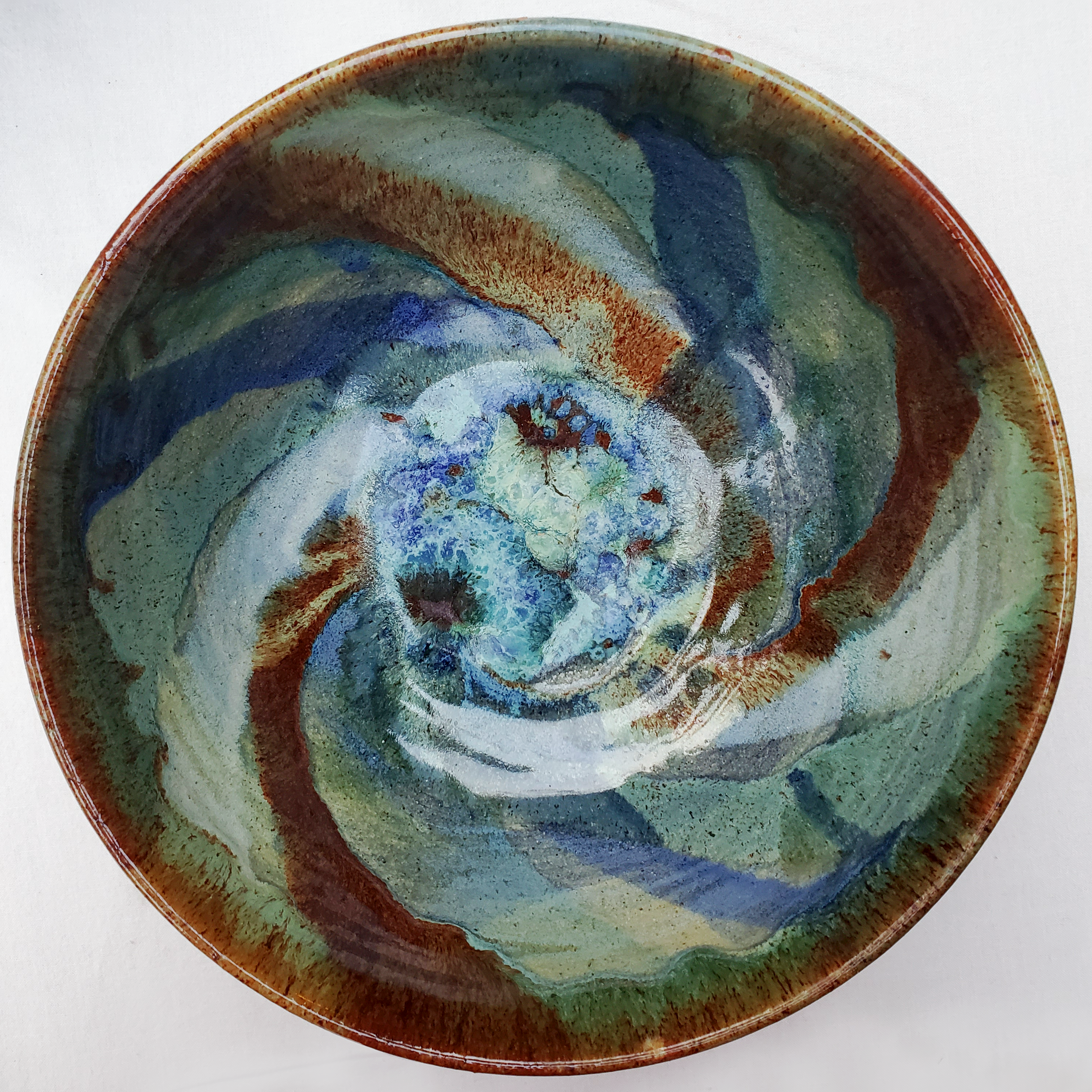 Beautiful bowls glazed with a galaxy swirl in blues, greens, yellows, browns, and reds. Handmade on Vashon Island by Abraham McBride Pottery. Local ceramics artist, Seattle Washington.